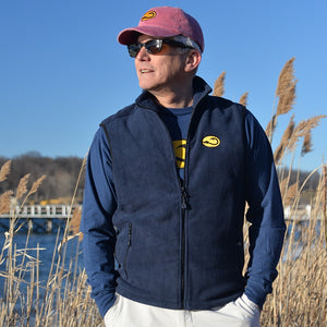 man wearing navy Fishers Fleece Vest by Hook Life on a beach